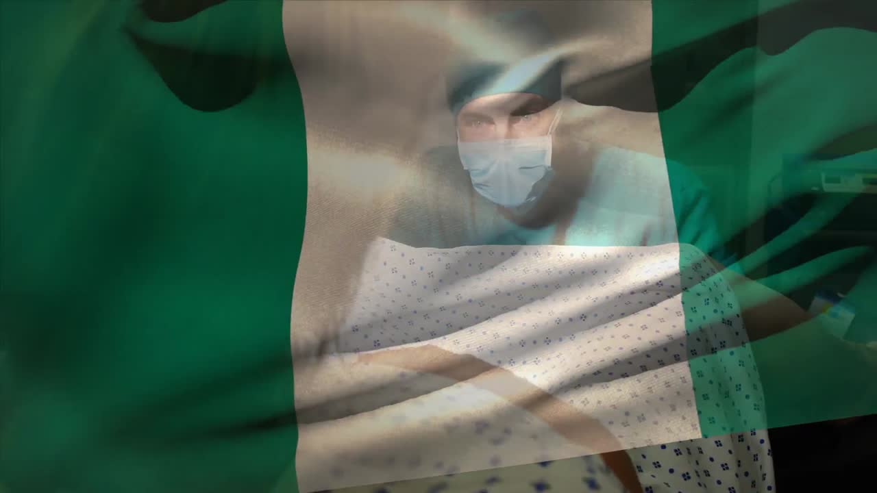 animación de la bandera de nigeria sobre un cirujano caucásico que opera a una mujer embarazada durante el parto