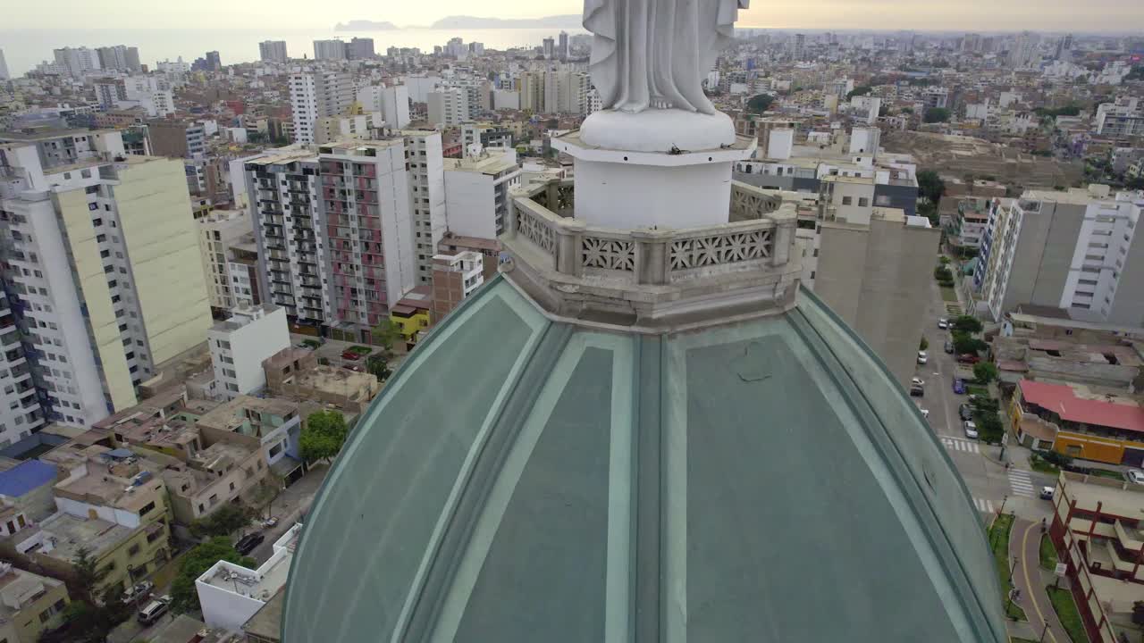 Vista aerea di una cupola di chiesa storica con statua che domina la città