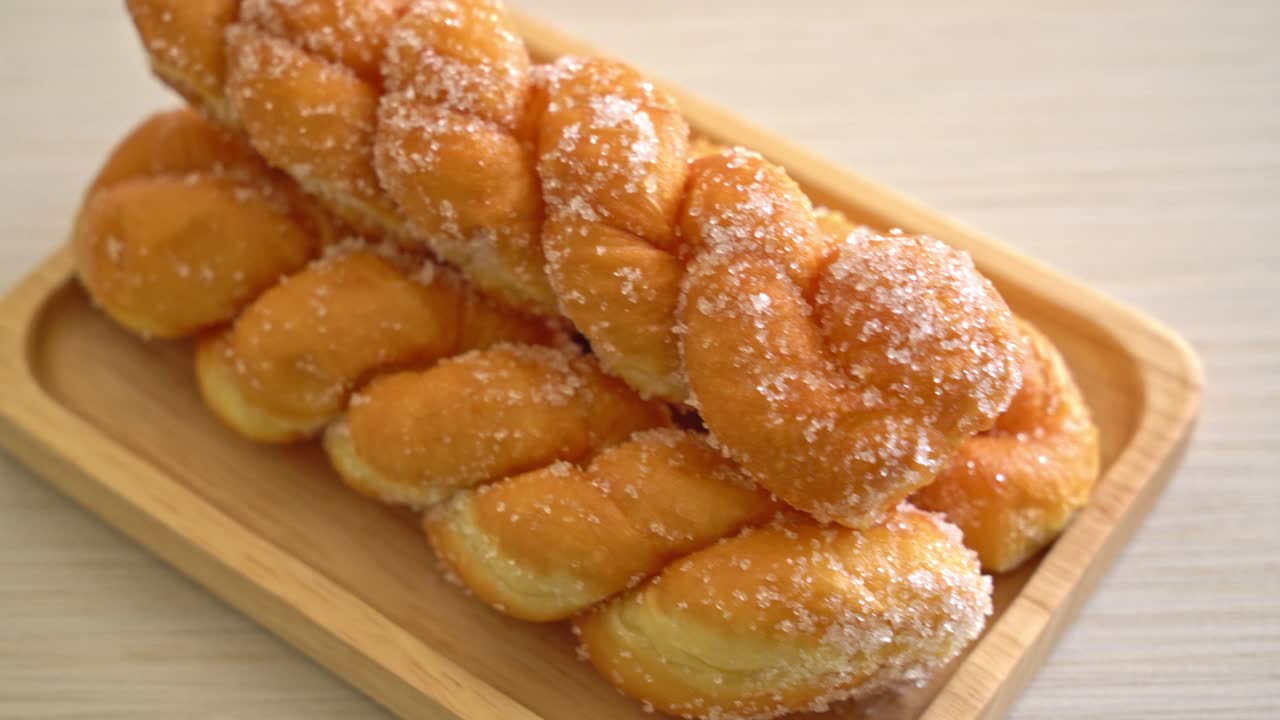 나무 접시에 나선형 모양의 설탕 도넛