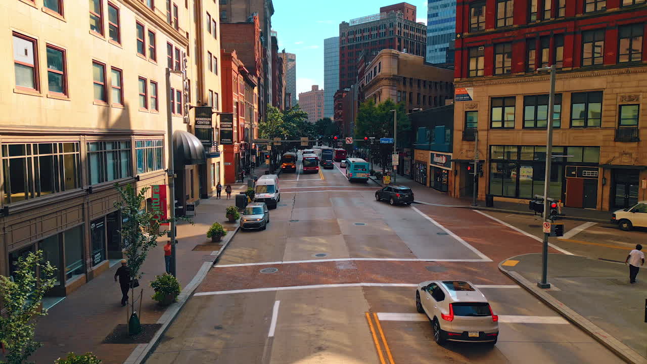 Cars and public transport moving by the wide street of a big city. Drone footage over the road in Pittsburg, Pennsylvania, USA