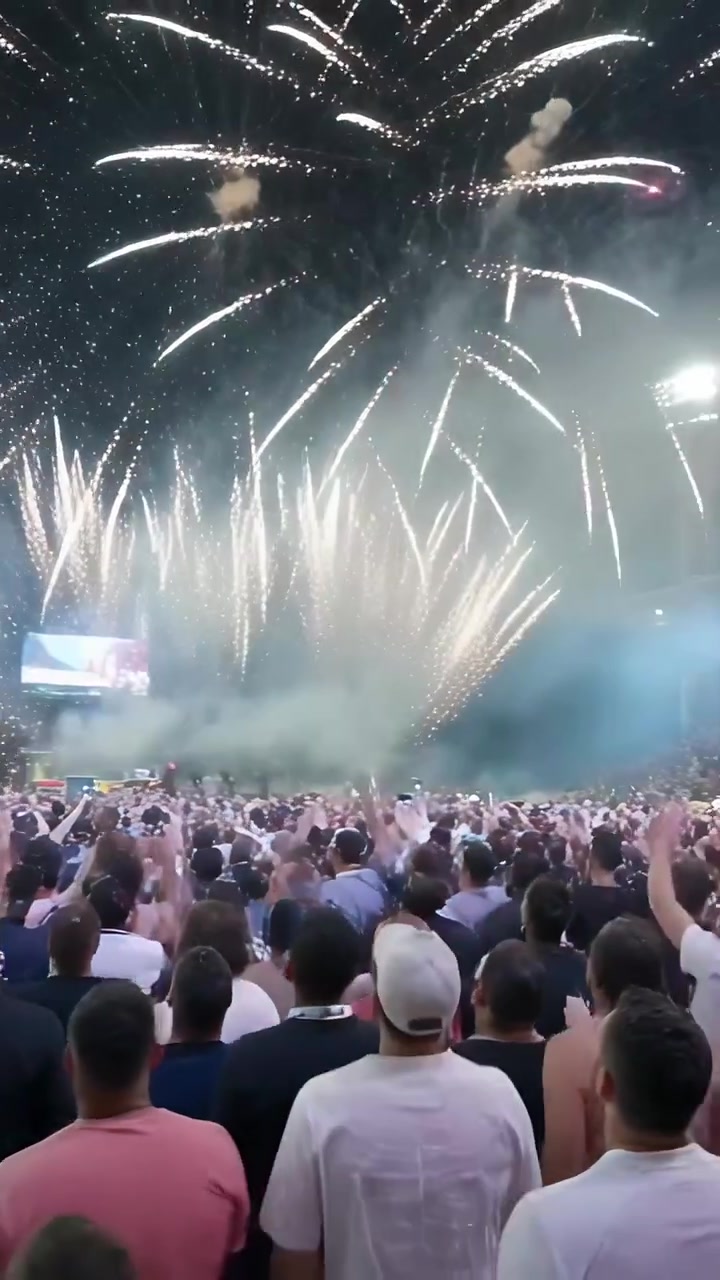 Video vertikal: Kerumunan merekam dengan mengangkat ponsel saat kembang api menyala di stadion dengan asap dan lampu