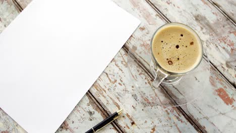 coffee cup, blank paper and pen on wooden plank