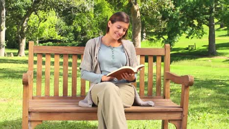 Mujer-Joven-Leyendo-Un-Libro-En-Un-Banco-Del-Parque.