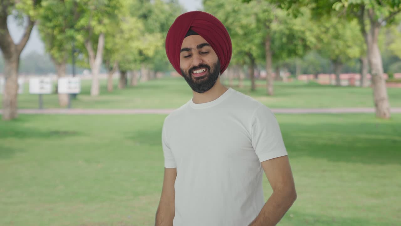 hombre indio sikh feliz llamando a alguien en el parque