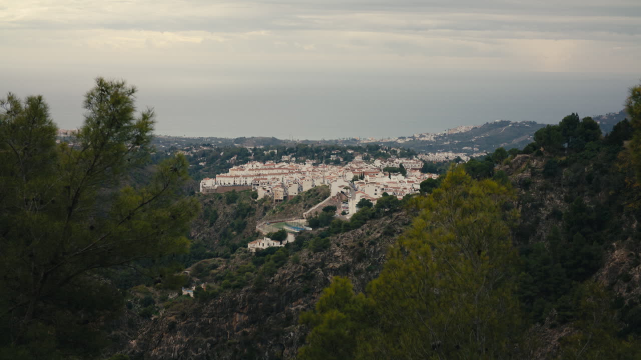 Frigiliana von oben, auf einem Hügel mit dramatischen Klippen und dem Meer in der Ferne