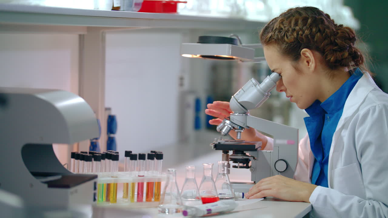 Woman scientist microscope research. Female scientist looking microscope