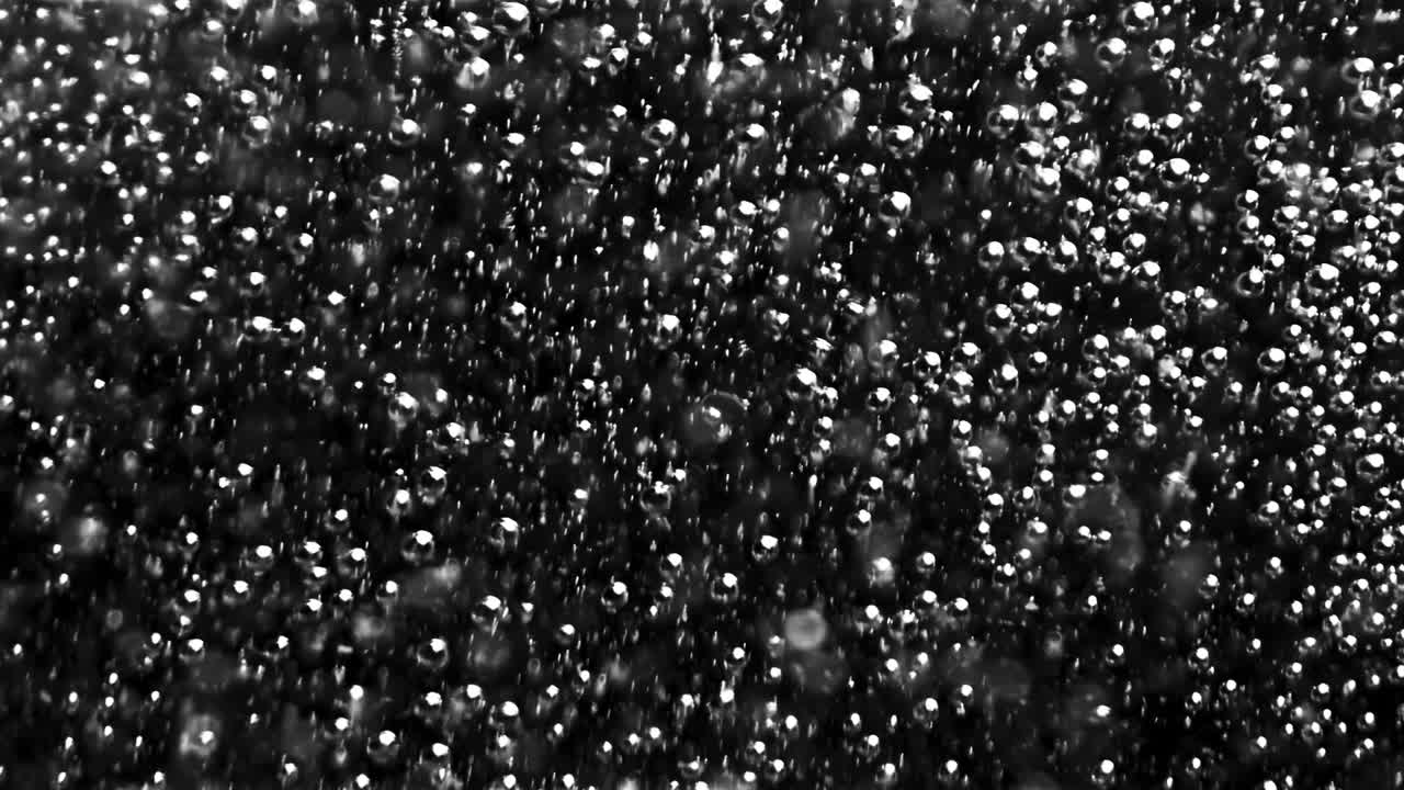 абстрактные воздушные пузырьки, движущиеся под водой. фотоаппарат. крупный план круглых прозрачных кислородных пузырей, медленно текущих, изолированных на черном фоне, монохромные