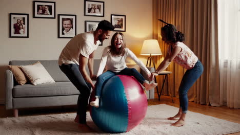 friends or family having fun playing with an exercise ball at home