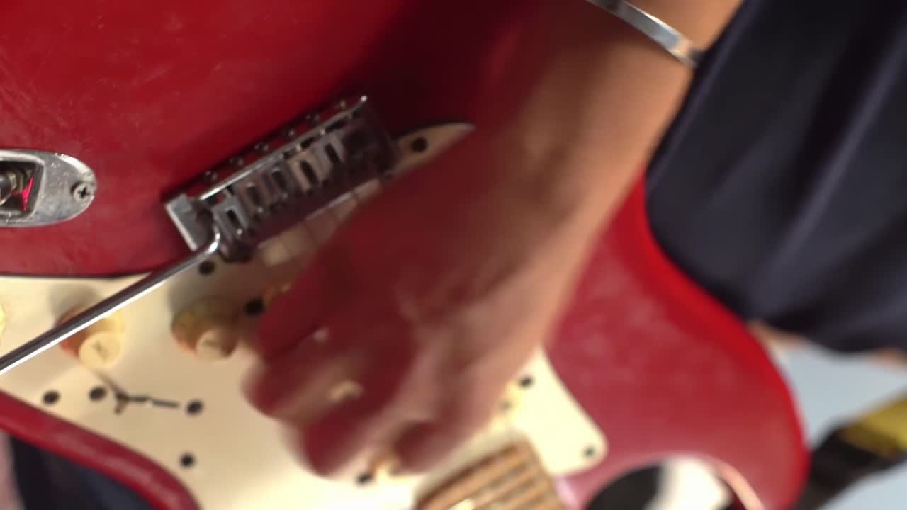 赤いエレキギターを速く弾く男性