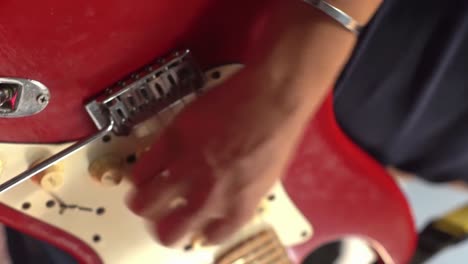 man playing a red electric guitar fast