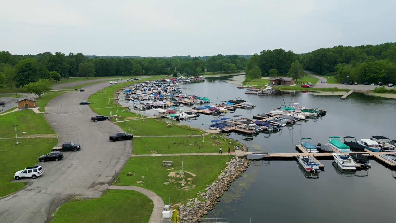 A bustling marina filled with colorful boats and vehicles parked nearby, showcasing a vibrant scene of recreational activity and watercraft lifestyle.