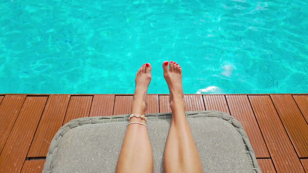 Viaggiatrice si gode la tranquilla atmosfera del resort accanto a una scintillante piscina blu.