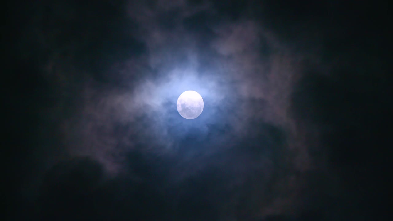 Vollmond bei Nacht mit vorbeiziehenden Wolken