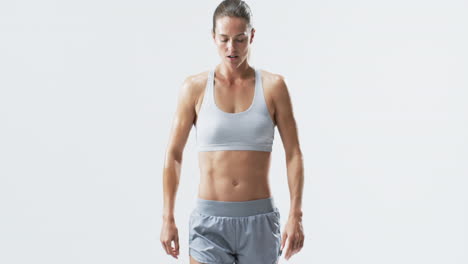 fit young caucasian woman athlete stands confidently on a white background, with copy space