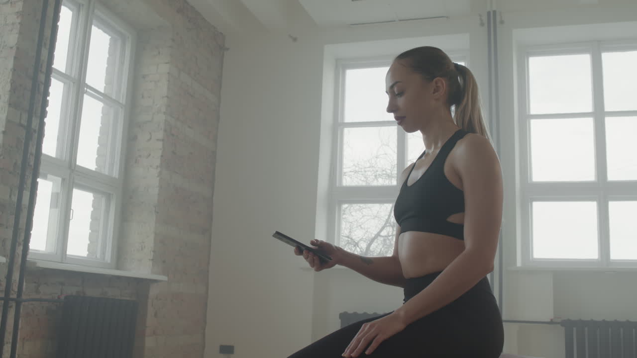 Sportive Girl Using Smartphone After Training At Gym