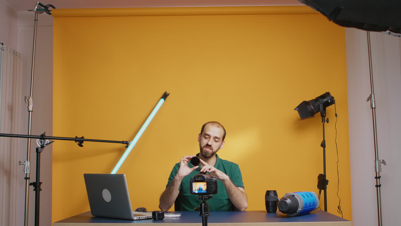 Vlogger de fotografía sosteniendo filtros ND redondos