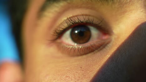 extreme close up of an eye of man blinking in front of camera