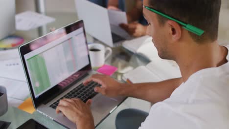 Close-up-of-latin-man-sitting-at-desk-and-working-on-laptop