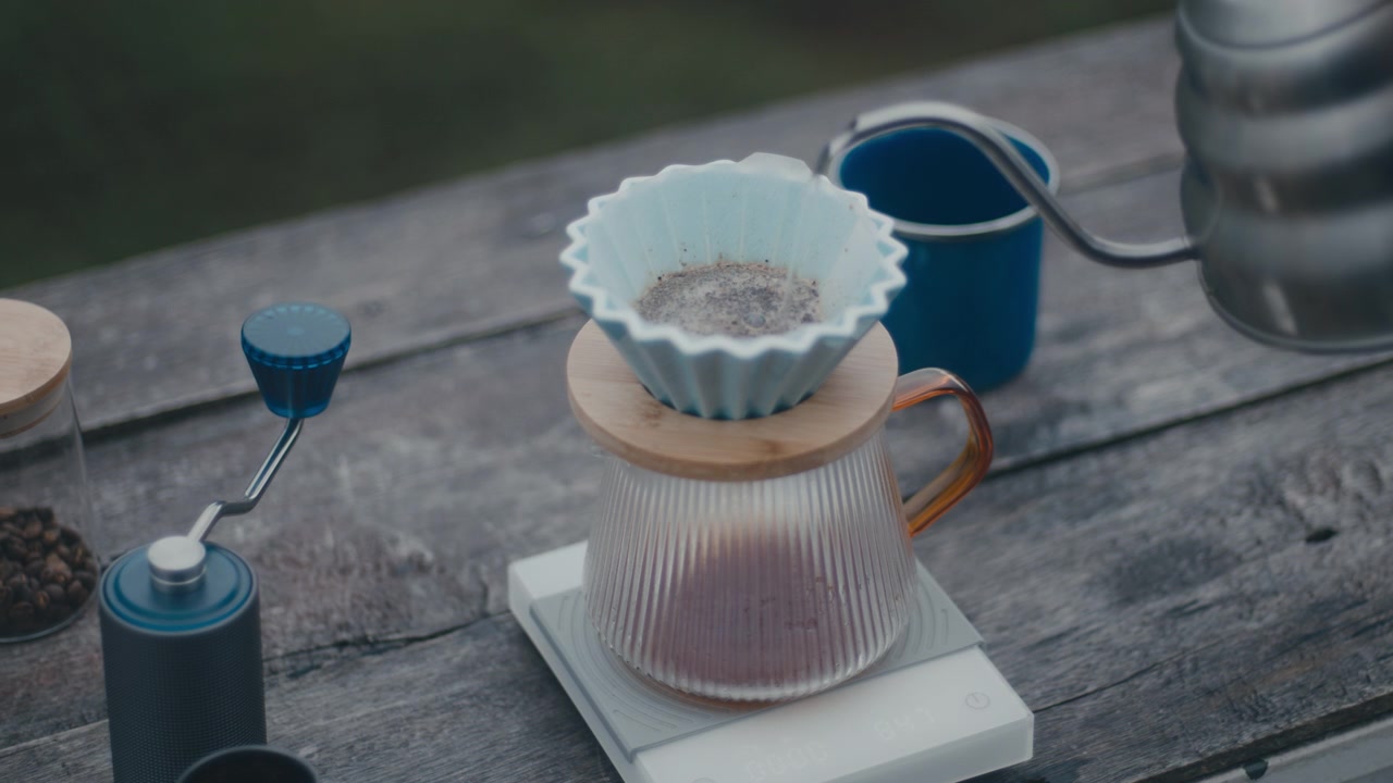 セラミックドリッパーに入ったコーヒー粉に熱いお湯を注ぐ様子