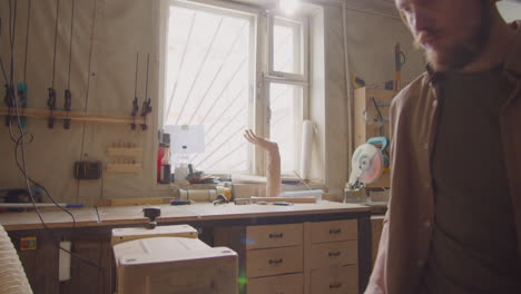 woodworker in safety earmuffs using thickness planer