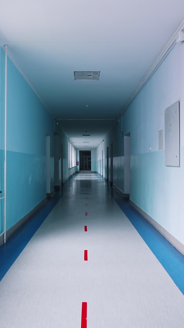 Modern hallway in educational center. Long corridor in blue color with doors and large windows in the university. Vertical video