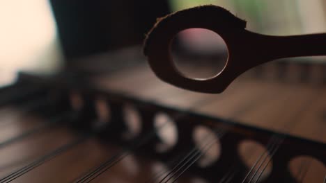 extreme close up of dulcimer appalachian traditional musical instrument, cinematic slow motion hammered string