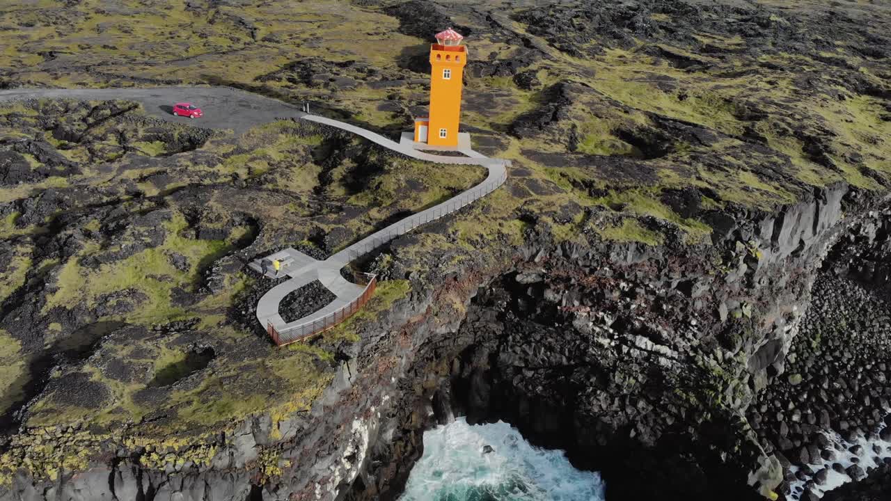 Aerial of Sv&ouml;rtuloft Lighthouse at a rocky coast with cliffs in Iceland