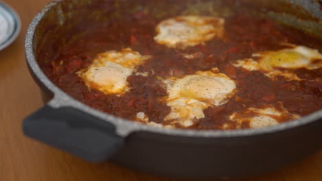 Agregando-Pimienta-Finamente-Molida-Al-Shakshuka-Casero-En-Cámara-Lenta