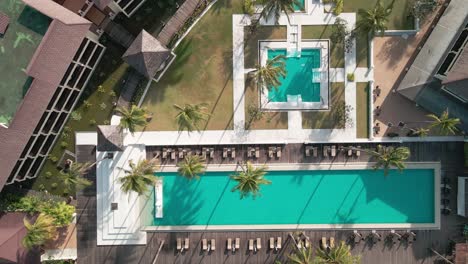 Drone-Descendiendo-Hacia-La-Piscina-En-Un-Resort,-Resort-Vacío-Sin-Personas-Capturadas-Por-Drones,-Tecnología-De-Drones-En-El-Sector-Turístico