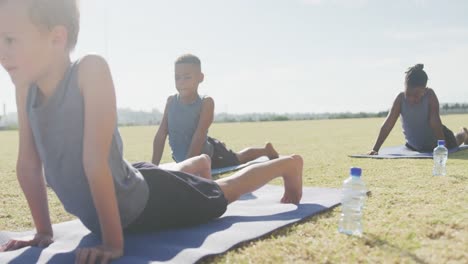 Video-Von-Konzentrierten,-Vielfältigen-Jungen,-Die-An-Einem-Sonnigen-Tag-Yoga-Auf-Matten-Praktizieren