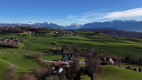 hermosas colinas verdes con un pequeño pueblo suizo durante un día soleado