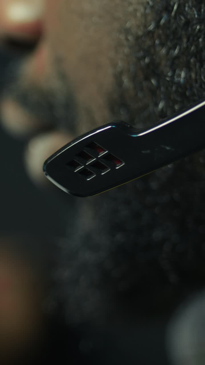 En mand, der spiller spil på en lodret video med hovedtelefoner for at fordybe sig bedre