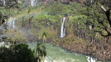 Huge-rocky-cliffs-forming-a-river-canyon-and-waterfalls-falling-down