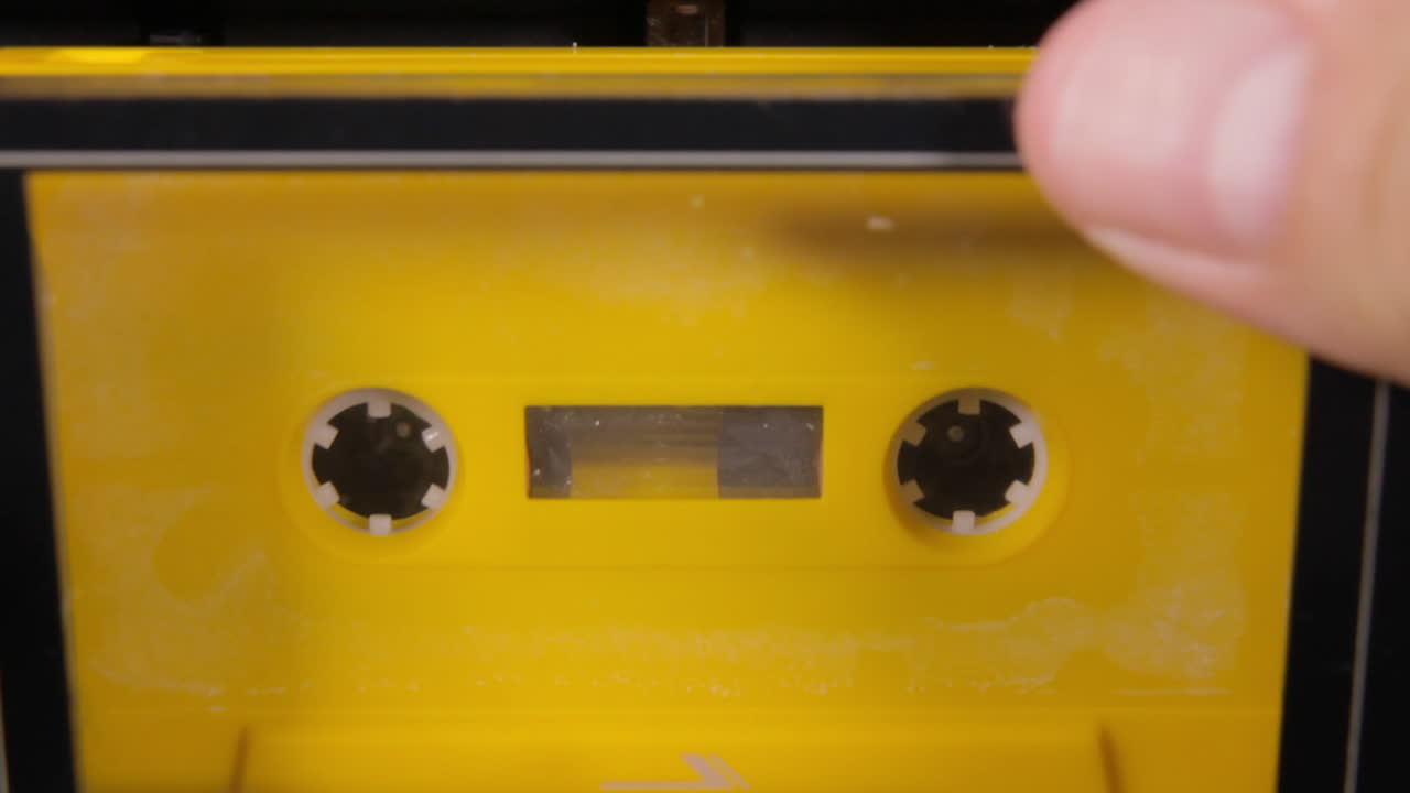 una cinta de cassette amarilla pegada en una baraja mientras se juega