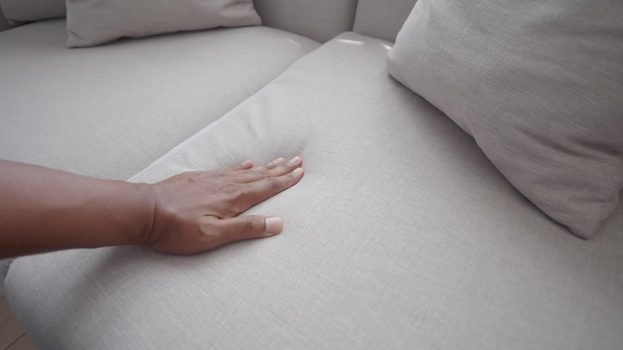 Close-up of a hand touching a couch