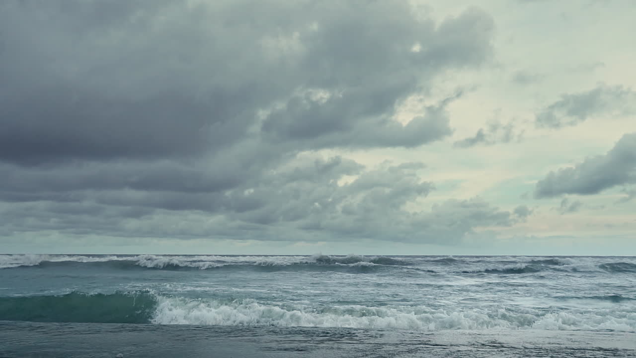 비가 오는 계절에 극적인 구름이 있는 바다 해변