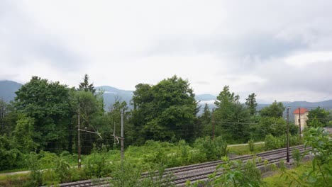 Zeitraffer-Ziehender-Wolken-Und-Dichter-Nebel-überziehen-Die-Landschaft-Und-Den-Himmel,-Bevor-Sich-Die-Wolkige,-Stimmungsvolle-Wolkenlandschaft-Auflöst-Und-Neu-Formiert,-Während-Züge-Auf-Schienen-Vorbeifahren