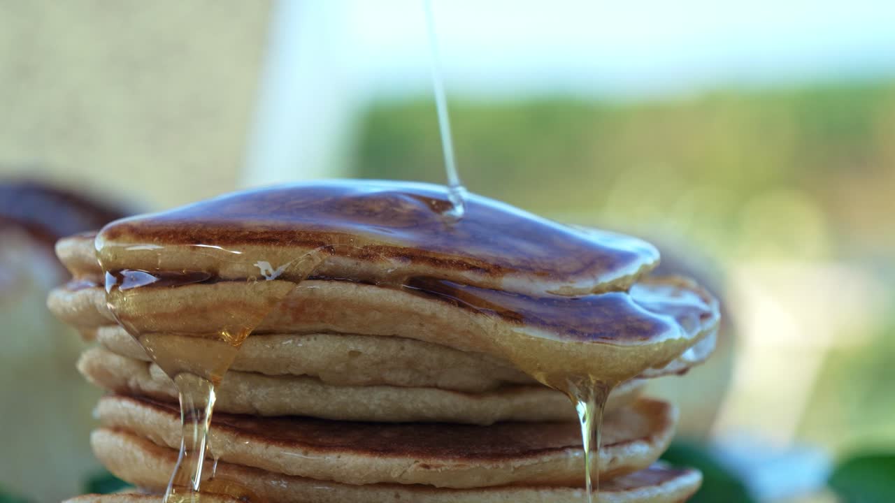jarabe de arce goteando sobre la pila de deliciosos panqueques para el desayuno
