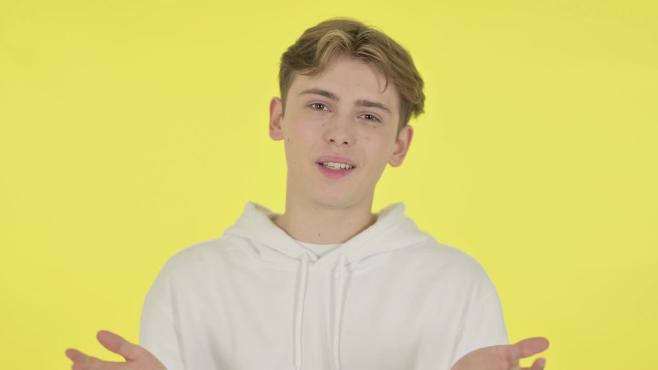 Young Man Talking on Online Video Chat on Yellow Background