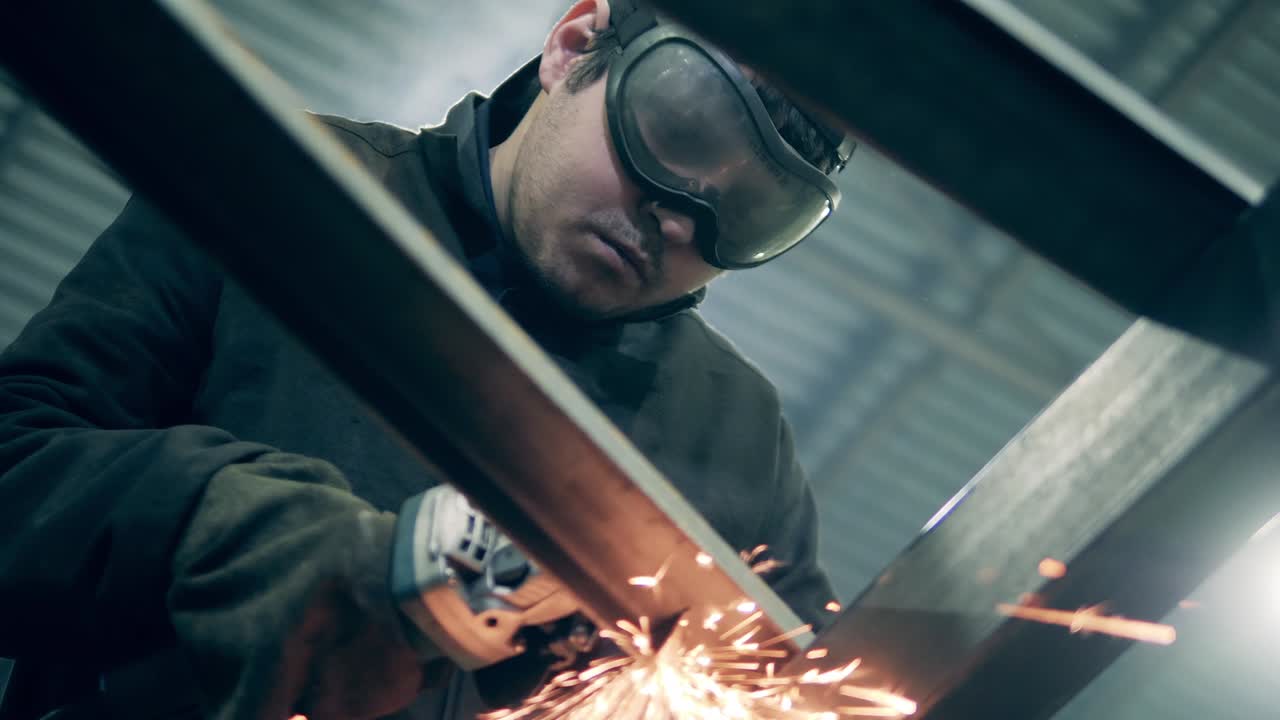 Svejser med vernebriller kutter metall og produserer mange gnister