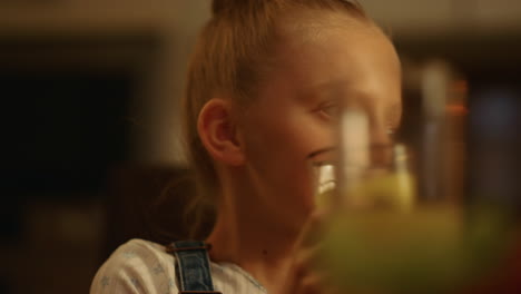 Mädchen-Hält-Ein-Glas-Saft-In-Der-Hand.-Fröhliches-Kind,-Das-Mit-Der-Familie-Auf-Eine-Brille-Klickt