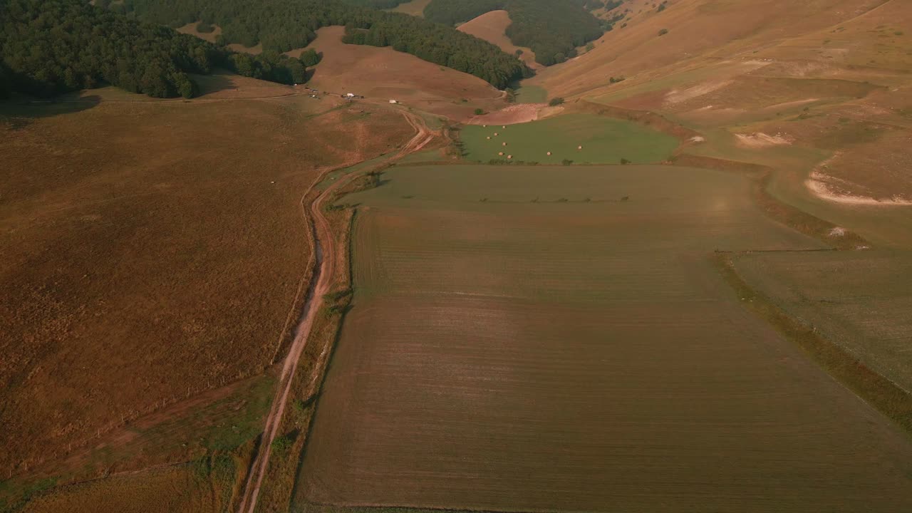 vasta pradera con densas montañas boscosas en una mañana soleada en umbría, italia