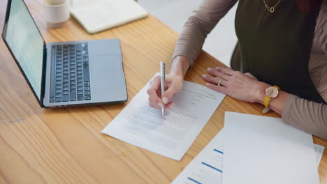 una mujer de negocios firmando un contrato en su escritorio.