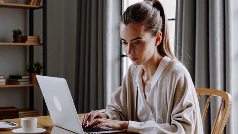 mujer de negocios enfocada escribiendo atentamente en su computadora portátil, trabajando desde una acogedora oficina en casa con una suave iluminación natural, rodeada de libros y una decoración elegante