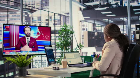 mujer de negocios viendo noticias y trabajando en computadoras portátiles en una oficina moderna