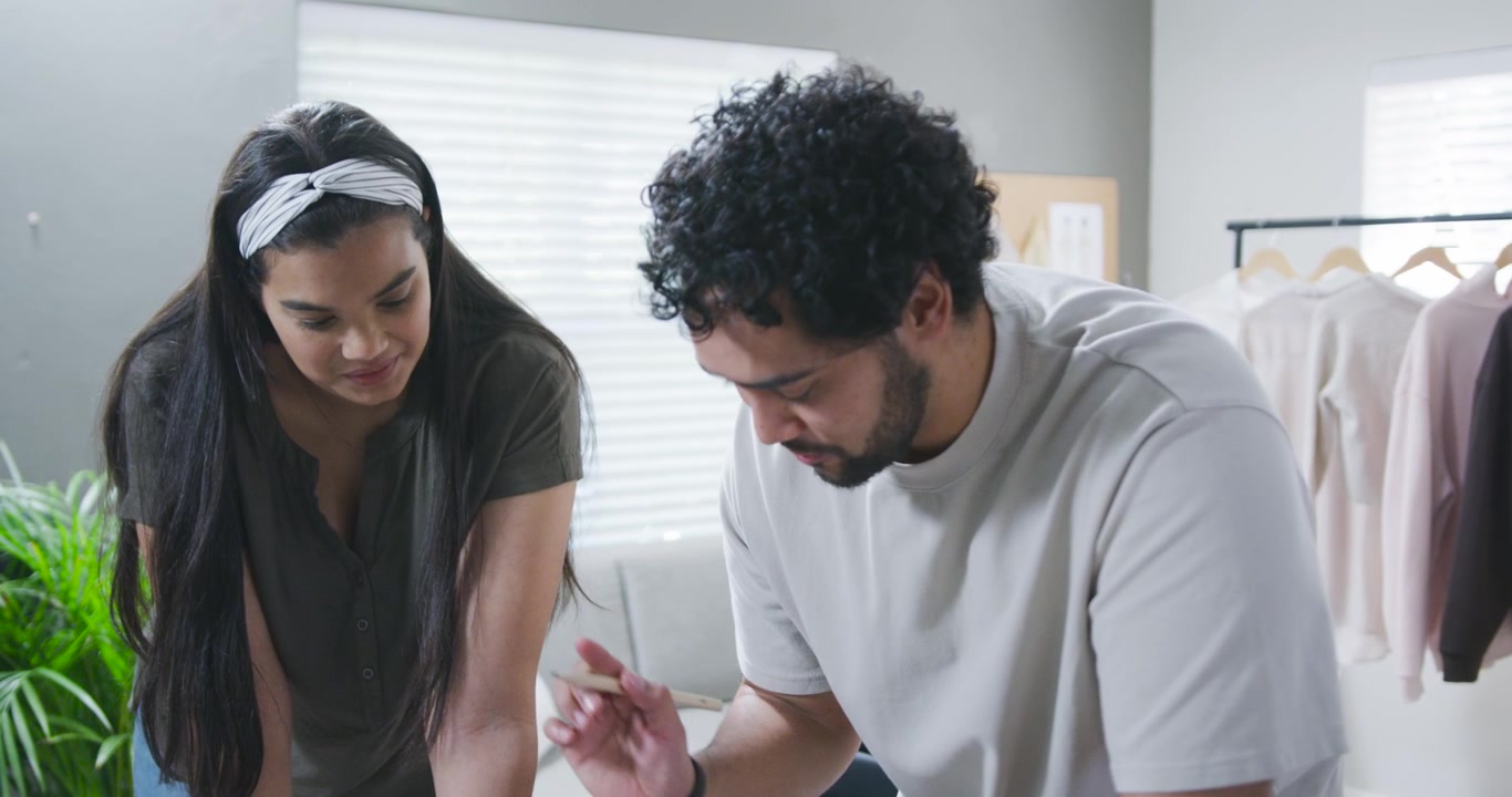 Casal jovem colaborando em um projeto criativo em casa