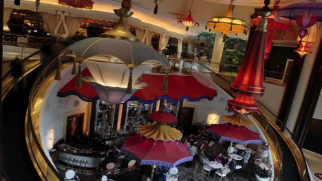 a time lapse of pedestrians using escalators while chandeliers move up and down