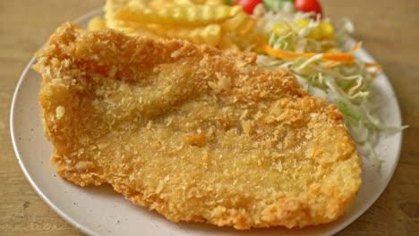 fried fish fillet and potatoes chips with mini salad