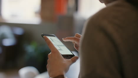 Close-up-of-womans-hands-using-smart-phone-technology-to-read-architectural-plans