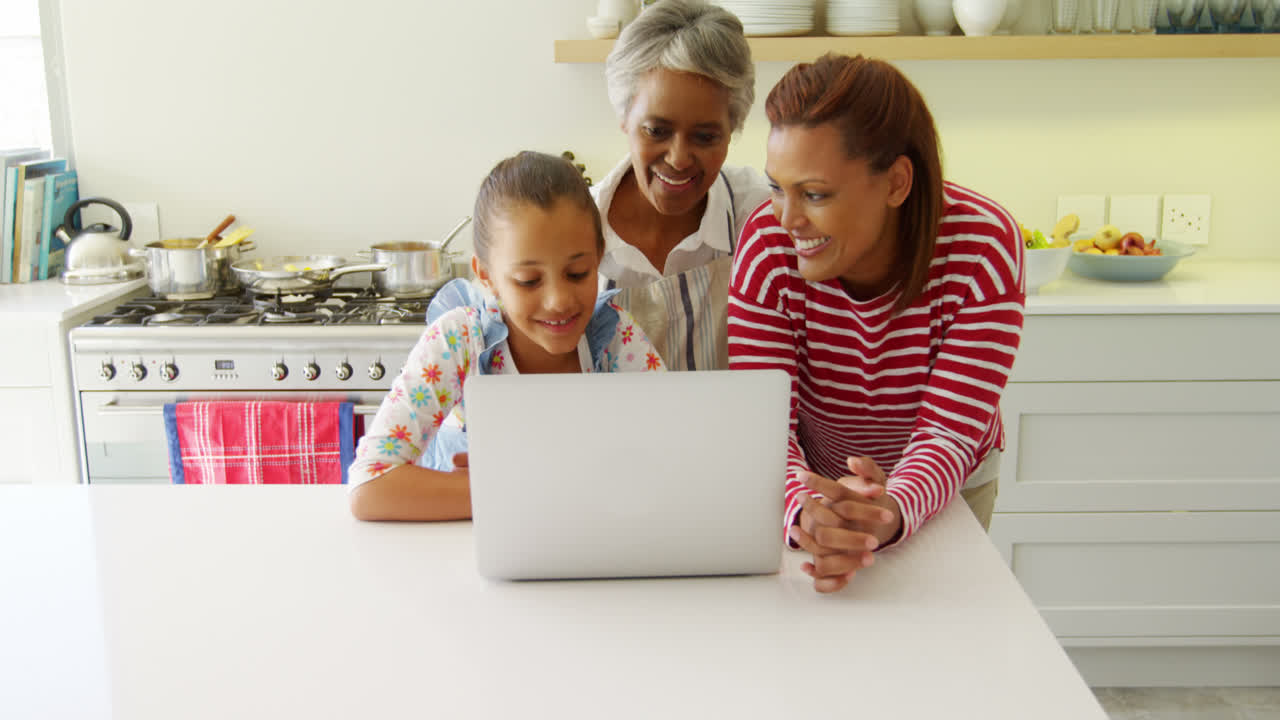 Mother and daughter using graphic tablet while looking at laptop 4k